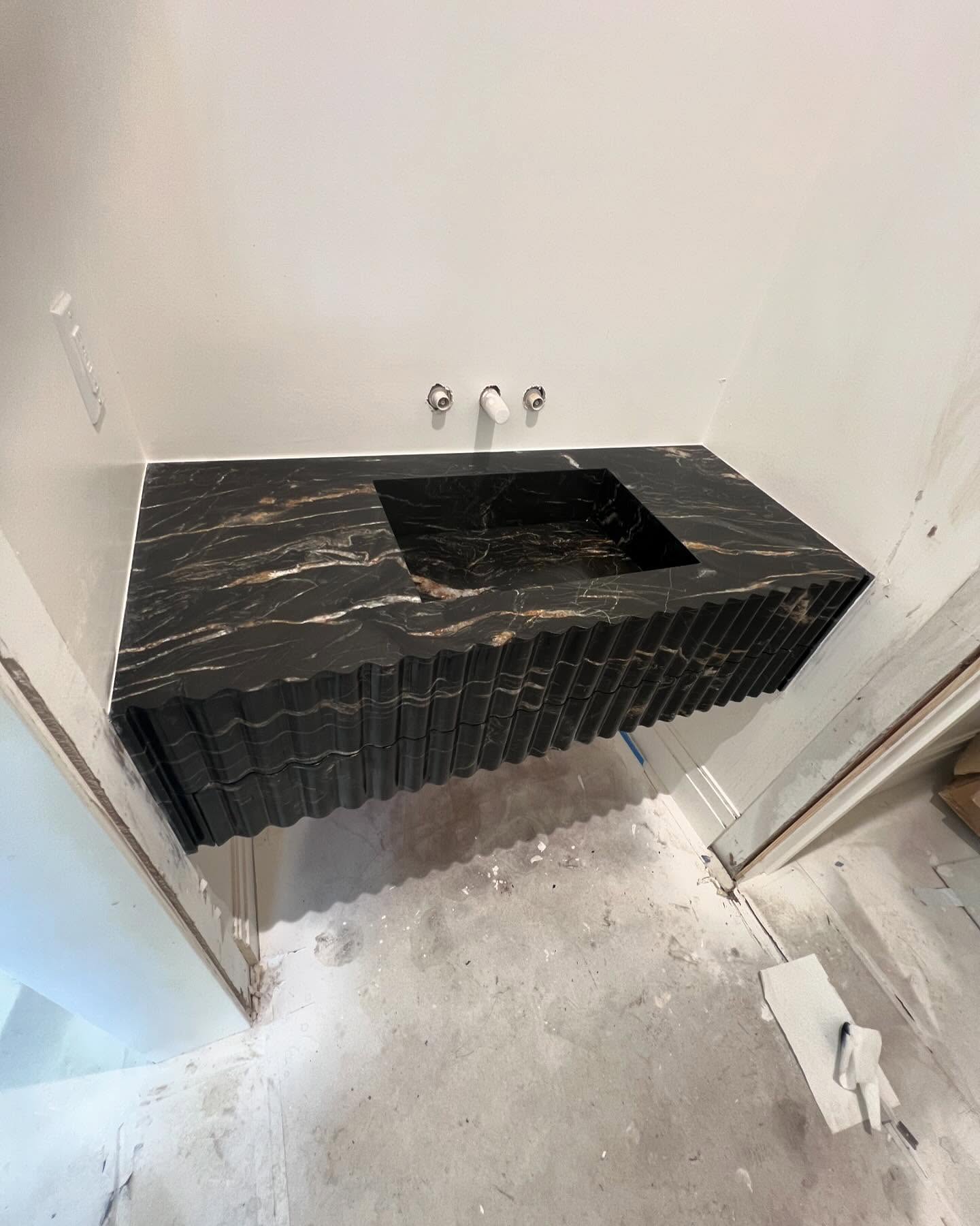 Vanity with integrated sink and fluted apron by Fine Stone Works